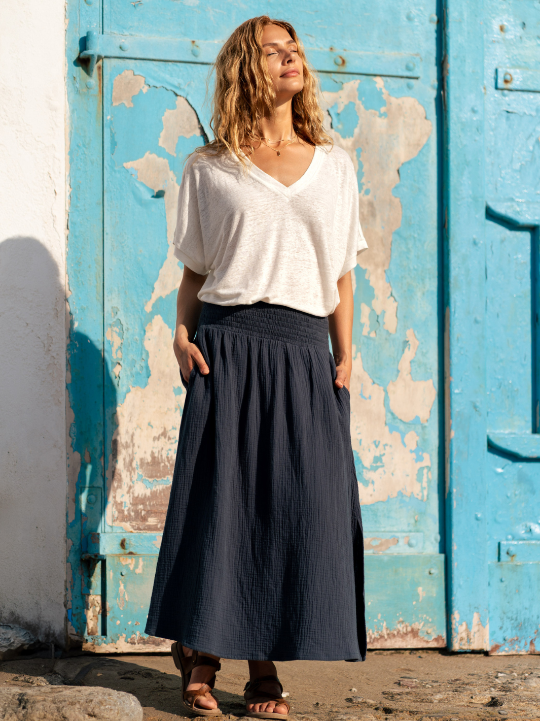 Woman wearing a white linen top and black cotton skirt.