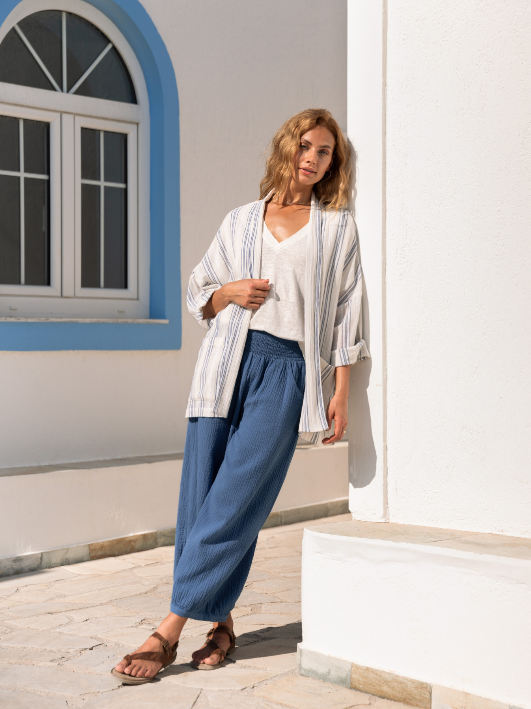 Woman wearing a white and blue cotton jacket and blue cotton pants.