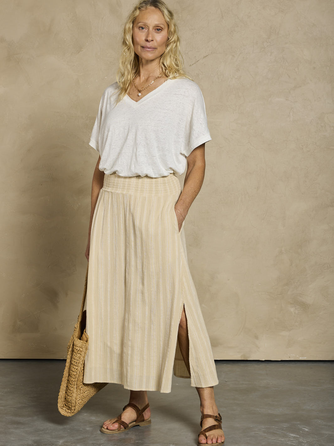 Woman in a white linen top and beige cotton skirt