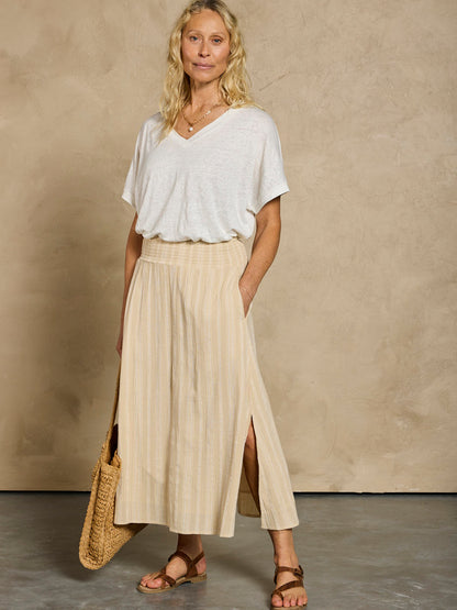 Woman in a white linen top and beige cotton skirt