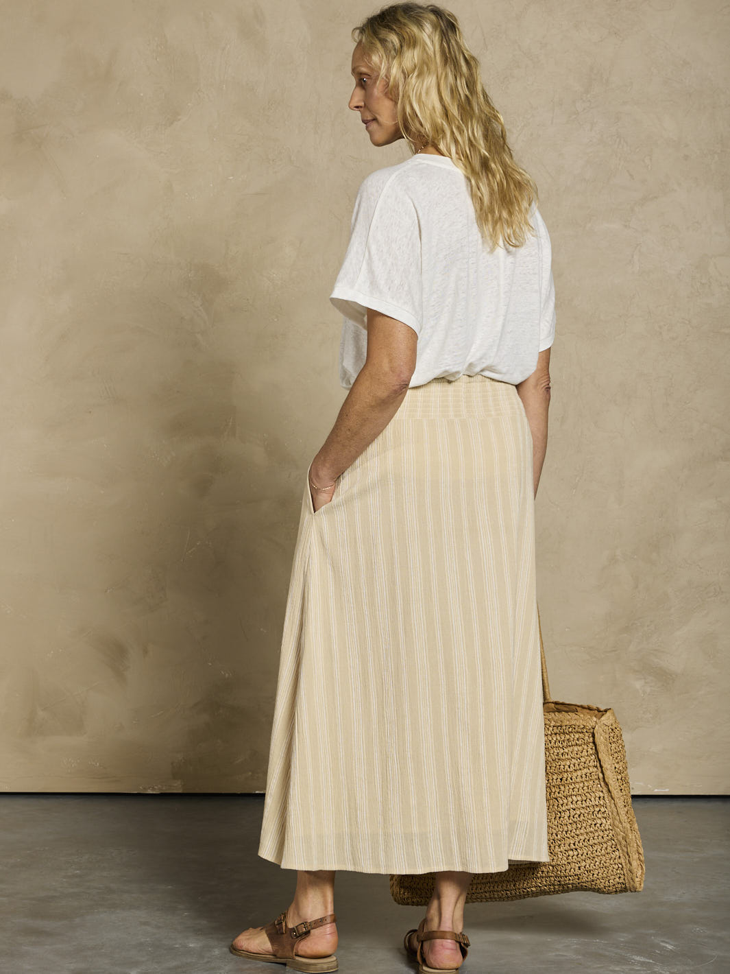 Woman in a white linen top and beige cotton skirt