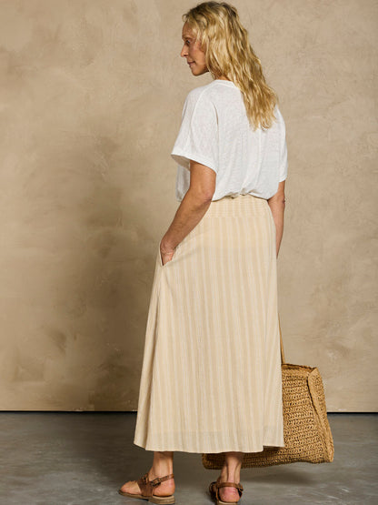 Woman in a white linen top and beige cotton skirt
