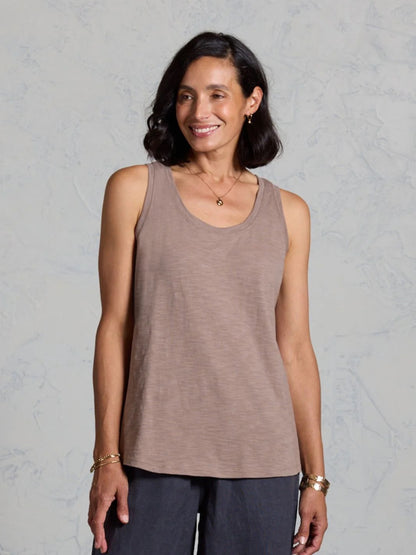 Woman wearing a brown tank top against a gray background